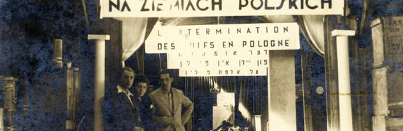 The Jewish survivor-curators posing below banners which read, in Polish, French, Yiddish and Hebrew “The Extermination of Jews in Poland.” GFH Catalog No. 38507. Ghetto Fighters' House Museum, Israel/Photo Archive